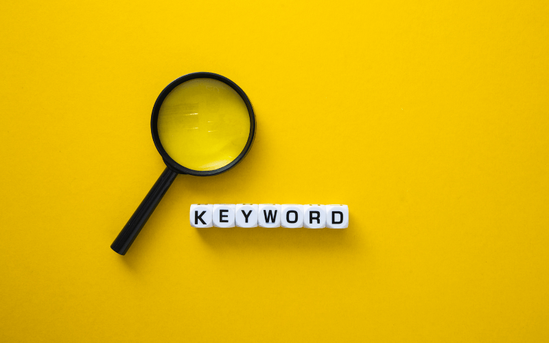 yellow background with magnifying glass showing keyword placement for seo